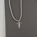 Collier Pendentif avec Perles Grises et Noeud de Papillon 